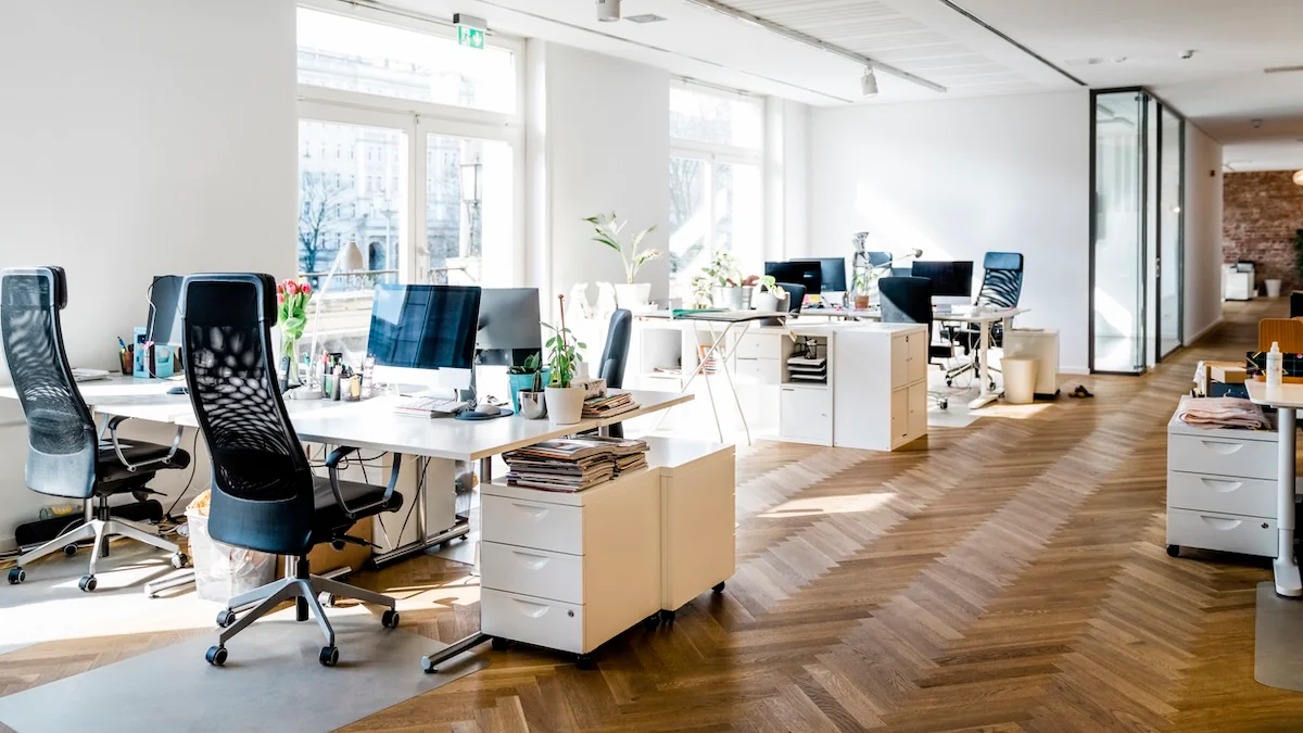 Gen Z Symbolbild: ein leeres modernes Büro mit Holzboden und vielen Schreibtischen mit Computern