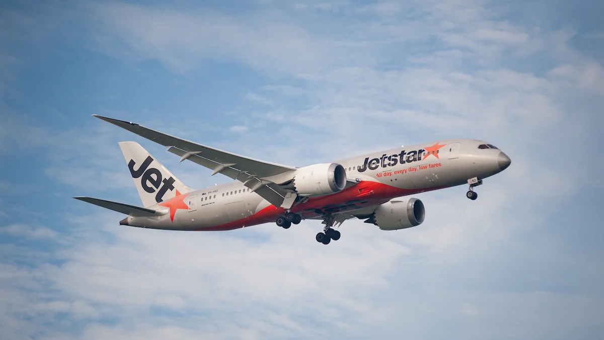Flugzeug von Jetstar Asia in der Luft vor blauem Himmel