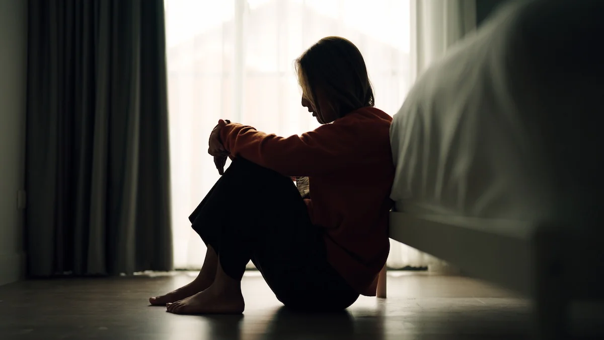 Montagsstress: Silhouette einer Frau, die vor ihrem Bett sitzt