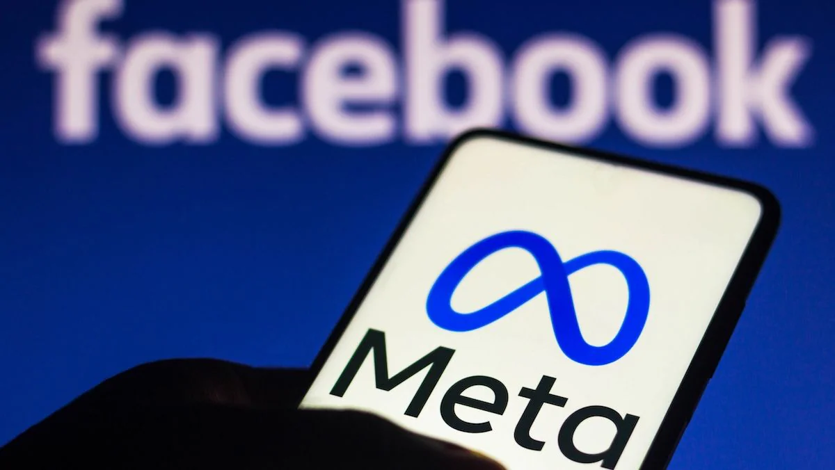 Mark Zuckerberg: Meta-Logo auf einem Smartphone, im Hintergrund ein Facebook-Schriftzug