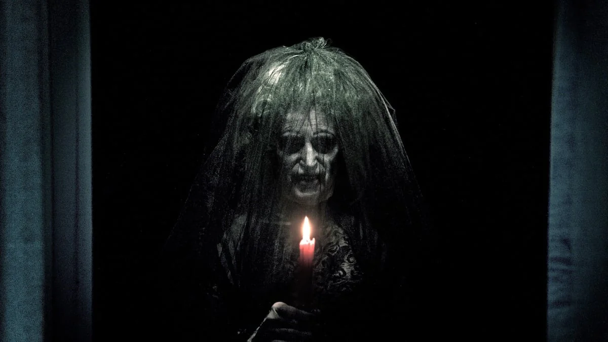 Szene aus dem Film „Insidious“, in der eine gruselige Gestalt eine Kerze hochhält