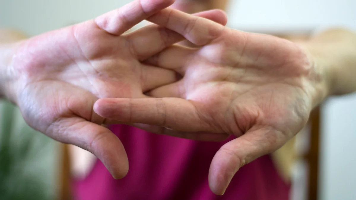 Ältere Frau beim Fingerknacken mit beiden Händen