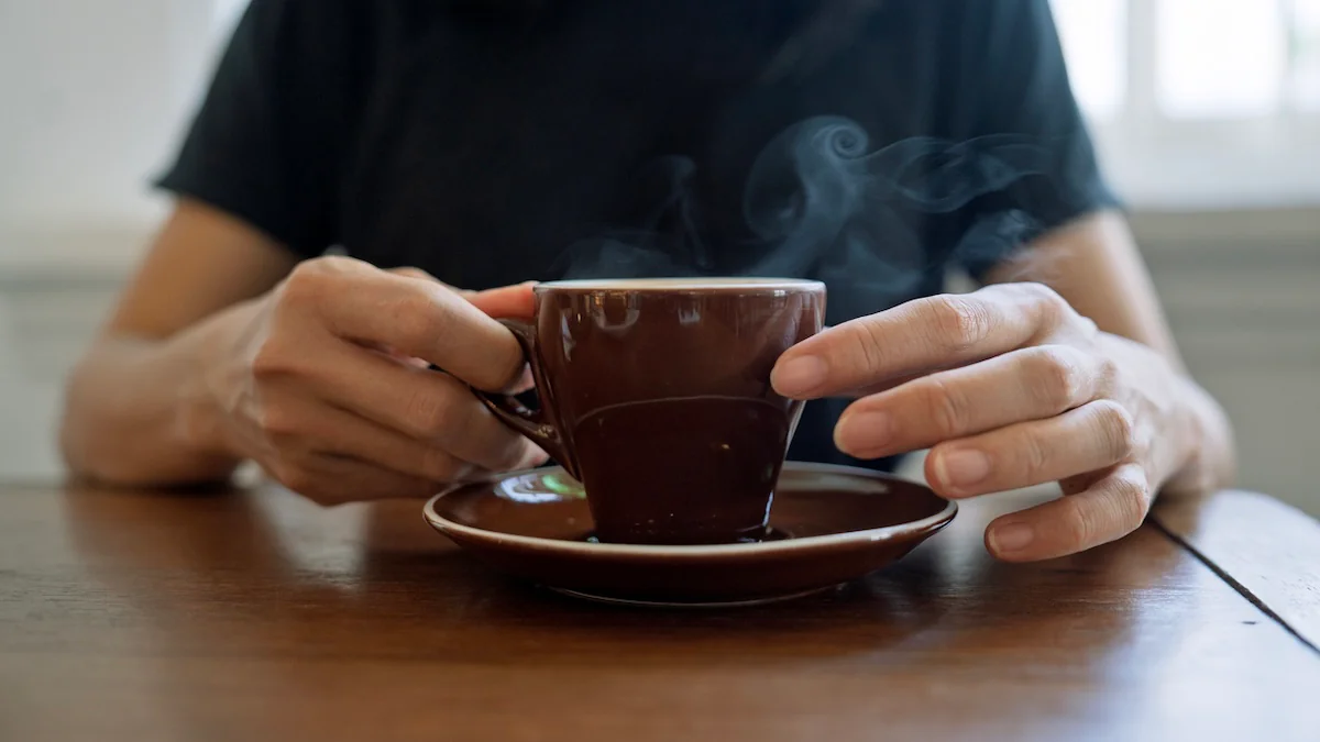 Krebsrisiko heiße Getränke: Jemand hält eine dampfende Tasse mit einem Getränk in der Hand