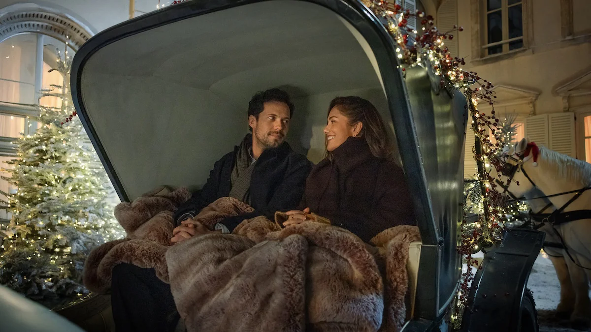 Szene aus „Champagne Problems“ bei Netflix, in der ein Mann und eine Frau im Winter in einer Kutsche sitzen