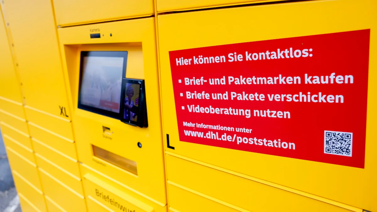 Eine neuartige Poststation, die verschiedene Möglichkeiten zum Empfang und Versand von Briefen und Paketen anbietet, steht in einem Wohngebiet.