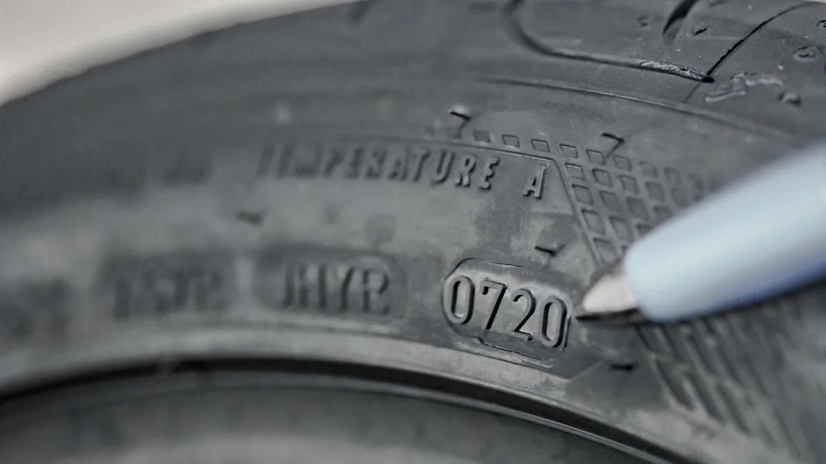 Reifenwechsel: Nahaufnahme eines Autoreifens, wobei ein Stift auf die vierstellige DOT-Nummer zeigt